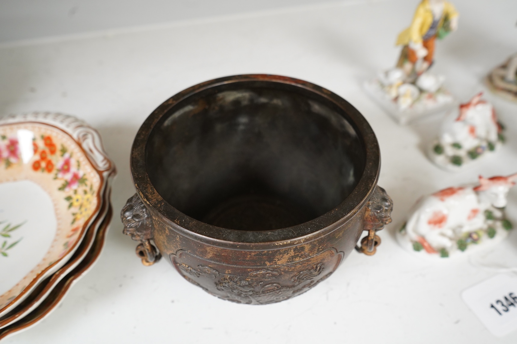 A Chinese partially gilt bronze censer, decorated in relief with twin handles, 16cm in diameter